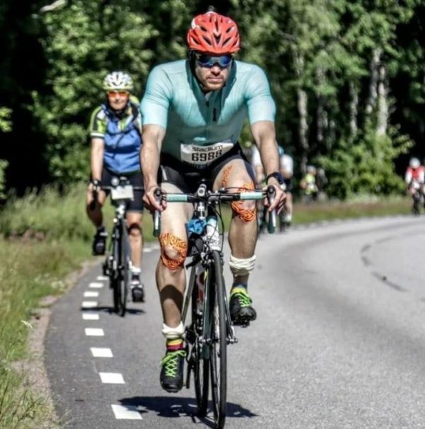 Blå cykeltröja i användning på landsväg med cyklist i fokus."